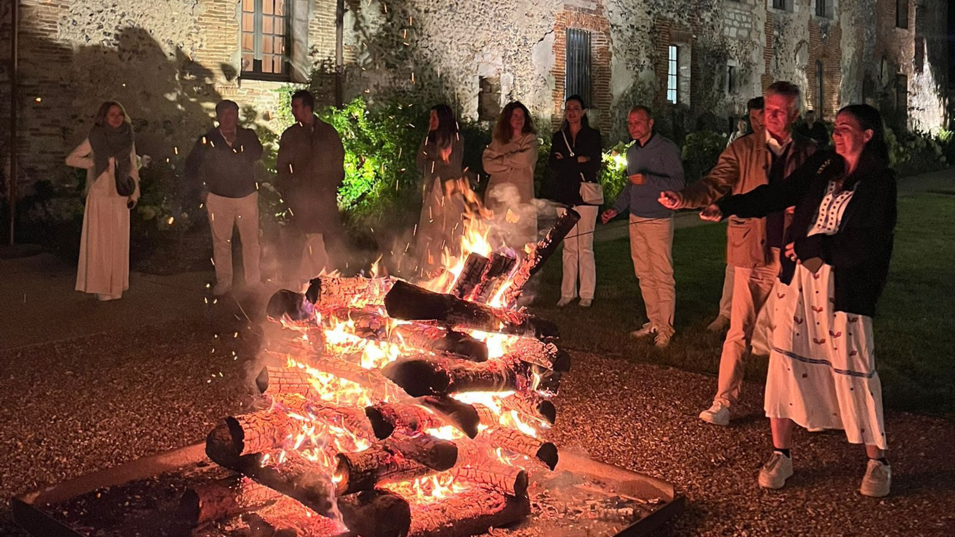Feu de bois en extérieur avec un groupe autour